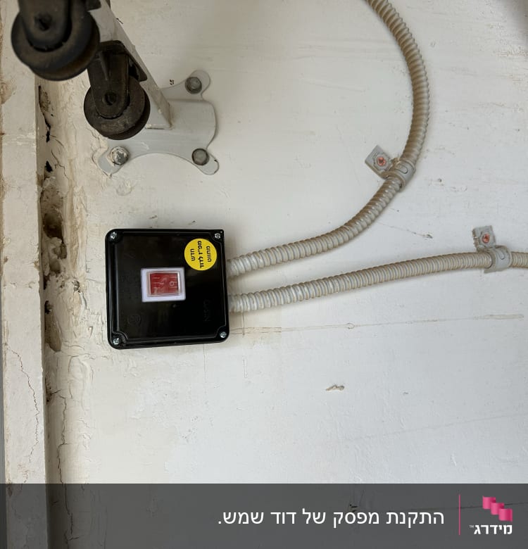 קופסת חשמל עם כפתור אדום וכבלים מחוברים